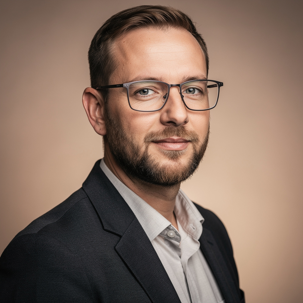 Studio portrait of a Belgian man with short beard and glasses